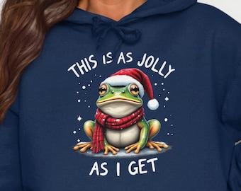 Può includere: Felpa con cappuccio blu navy con una grafica bianca di una rana che indossa un cappello da Babbo Natale. Il testo sulla grafica dice "This is as jolly as I get."