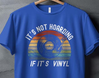 May include: A blue t-shirt with a vintage-style graphic of a record player and the text "It's not hoarding if it's vinyl."