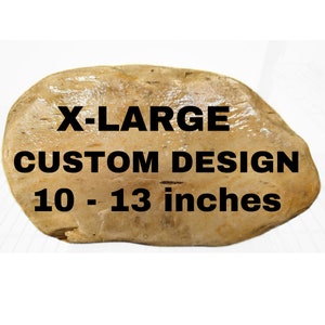 May include: A light brown, irregularly shaped rock with the text "X-LARGE CUSTOM DESIGN 10 - 13 inches" printed in black.