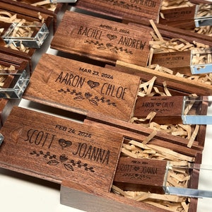May include: Wooden boxes with engraved names and dates, each containing a crystal USB drive. The boxes are stacked on top of each other, with the top box open to reveal the USB drive inside.