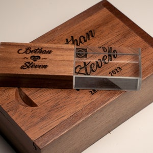 May include: A wooden box with a clear acrylic USB drive inside. The box and drive are engraved with the names "Bethany" and "Steven" and the date "2023".
