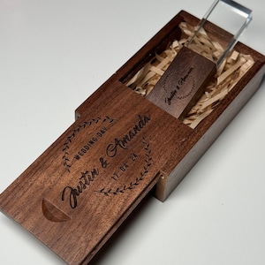May include: A wooden box with a clear acrylic lid, containing a USB drive with the text "Justin & Amanda" and the date "17.04.24" engraved on it. The box is also engraved with the text "Wedding Day Justin & Amanda 17.04.24".
