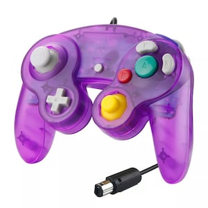 May include: A transparent purple video game controller with a black cable. The controller has a yellow joystick, white buttons, and colored buttons. The text "START/PAUSE" is printed on the controller.