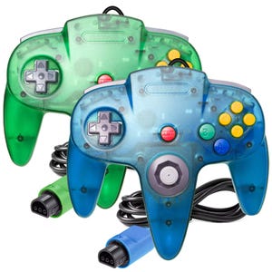 May include: Two transparent N64 controllers, one green and one blue, with black cables and colored buttons. The controllers have a classic design with a directional pad, start button, and analog stick. The controllers are for a gaming console.