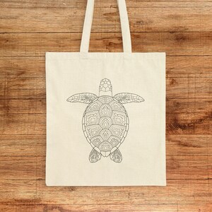 May include: A white canvas tote bag featuring a black line drawing of a sea turtle on the front. The turtle is facing downwards with its shell visible.