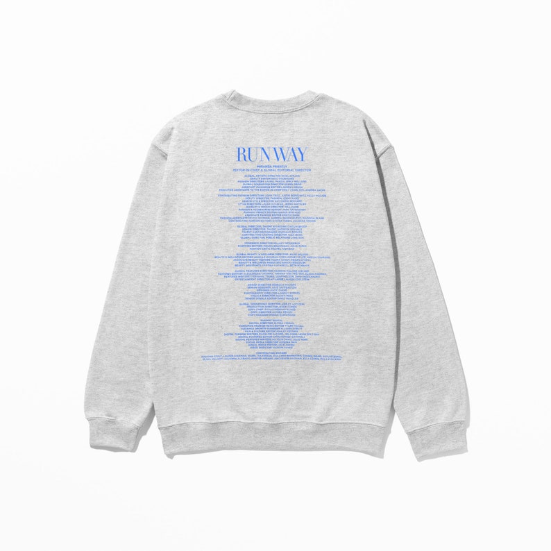 Pode incluir: Camisola de moletom cinza com mangas compridas e gola redonda. A parte de tr&aacute;s da camisola tem uma estampa azul que diz "RUNWAY" e inclui uma lista de palavras e frases.
