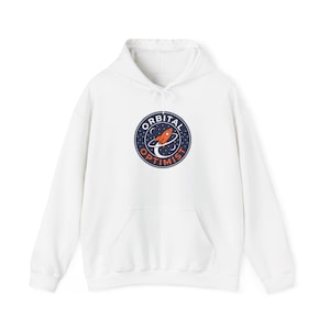 Può includere: Felpa con cappuccio bianca con tasca frontale e coulisse. La felpa presenta una grafica circolare con un razzo e le parole "ORBITAL OPTIMIST" in blu navy e arancione.
