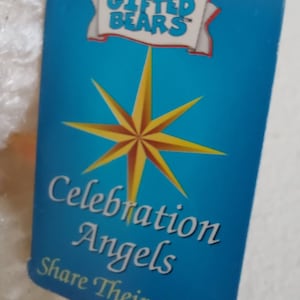 May include: A blue tag with a white star and the text "Gifted Bears" in a white banner. The text "Celebration Angels Share Their Love" is written in white on the tag.