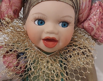 Vintage 1990s ltalian porcelain baby doll dressed in a Harlequin jester outfit