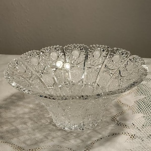 May include: A clear glass bowl with a cut glass design. The bowl is large and has a wide, shallow base.