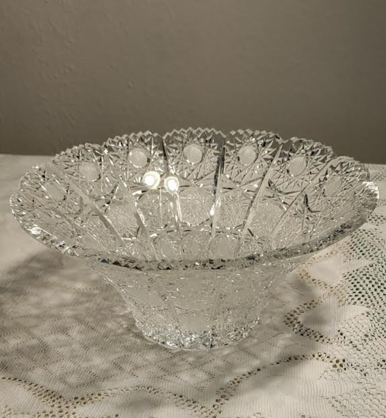 May include: A clear glass bowl with a cut glass design. The bowl is large and has a wide, shallow base.