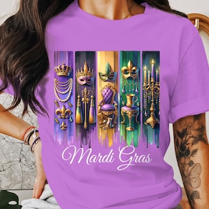 マルディグラをテーマにしたTシャツ、カラフルなマスクとビーズ、お祭り気分のニューオーリンズデザイン、鮮やかなパーティーTシャツ、マルディグラTシャツ、フェスティバルアートTシャツ