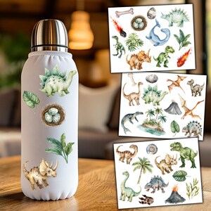 K&ouml;nnte beinhalten: Eine wei&szlig;e isolierte Wasserflasche mit verschiedenen Dinosaurier-Aufklebern. Die Aufkleber zeigen Dinosaurier, Eier, Palmen und einen Vulkan.