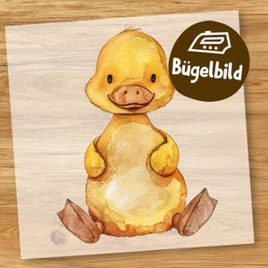 Peut inclure: Transfert thermocollant d'un adorable petit canard jaune avec un gros ventre et de petits pieds. Le caneton est assis sur une surface en bois. Le texte "Bügelbild" est dans un rectangle brun au-dessus du caneton.