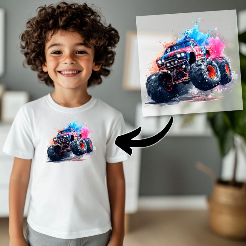 May include: A white t-shirt featuring a colorful watercolor illustration of a monster truck. The truck is red and blue with large black tires and is surrounded by splashes of pink and blue paint. The image is also displayed on a framed print.