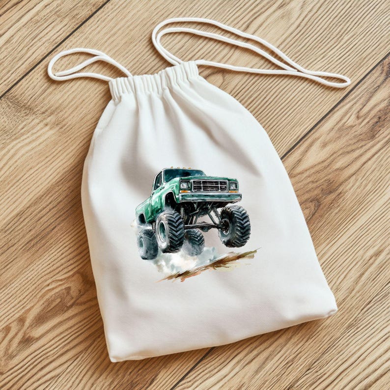 Puede incluir: Una bolsa de tela blanca con un gr&aacute;fico de cami&oacute;n monstruo verde impreso en la parte delantera. El cami&oacute;n est&aacute; conduciendo por un camino de tierra y levantando polvo.