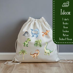K&ouml;nnte beinhalten: Eine wei&szlig;e Kordeltasche mit verschiedenen Dinosaurier- und tropischen Pflanzenillustrationen. Die Tasche ist aus Canvas und hat einen Kordelverschluss. Der Text "Ideen: T-shirts, Hoodies, Hosen, Taschen, M&uuml;tzen, Decken & Kissen" ist auf der rechten Seite der Tasche aufgedruckt.