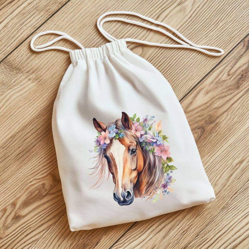 May include: White drawstring bag featuring a watercolor illustration of a horse's head adorned with a floral crown. The horse has brown and white markings, with a flowing mane. The flowers are in shades of pink, blue, and purple.