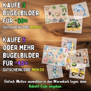 May include: Various iron-on transfer designs on a wooden surface. Designs include dinosaurs, a dolphin, a tractor, sea creatures, bears, and a dump truck. Text in German offers discounts with the codes MOKO3 and MOKO5.