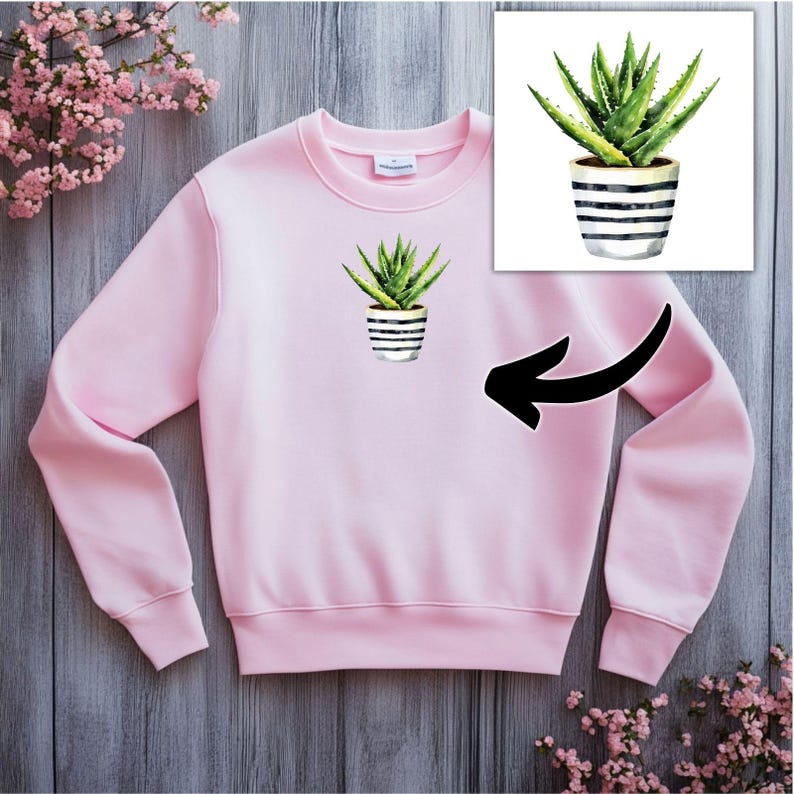 May include: A pink sweatshirt with a green aloe vera plant in a white and black striped pot printed on the front.