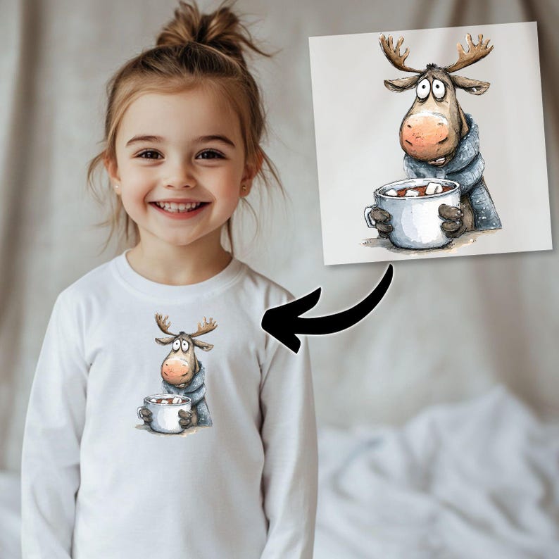 May include: White long-sleeve shirt featuring a cartoon moose holding a mug of hot chocolate. The moose is wearing a blue scarf. The shirt is worn by a young girl.