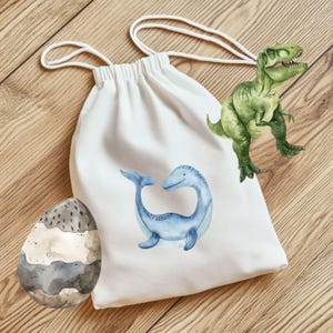 May include: White drawstring bag with a blue plesiosaur illustration. A green Tyrannosaurus Rex and a decorative egg are also in the image. The bag is made of a soft material and has a white drawstring closure.