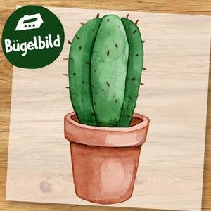 Könnte beinhalten: Eine Aquarellillustration eines grünen Kaktus mit kleinen braunen Dornen in einem terrakottafarbenen Topf. In der oberen linken Ecke befindet sich ein dunkelgrünes kreisförmiges Abzeichen mit einem weißen Bügeleisensymbol und dem Text Bügelbild.