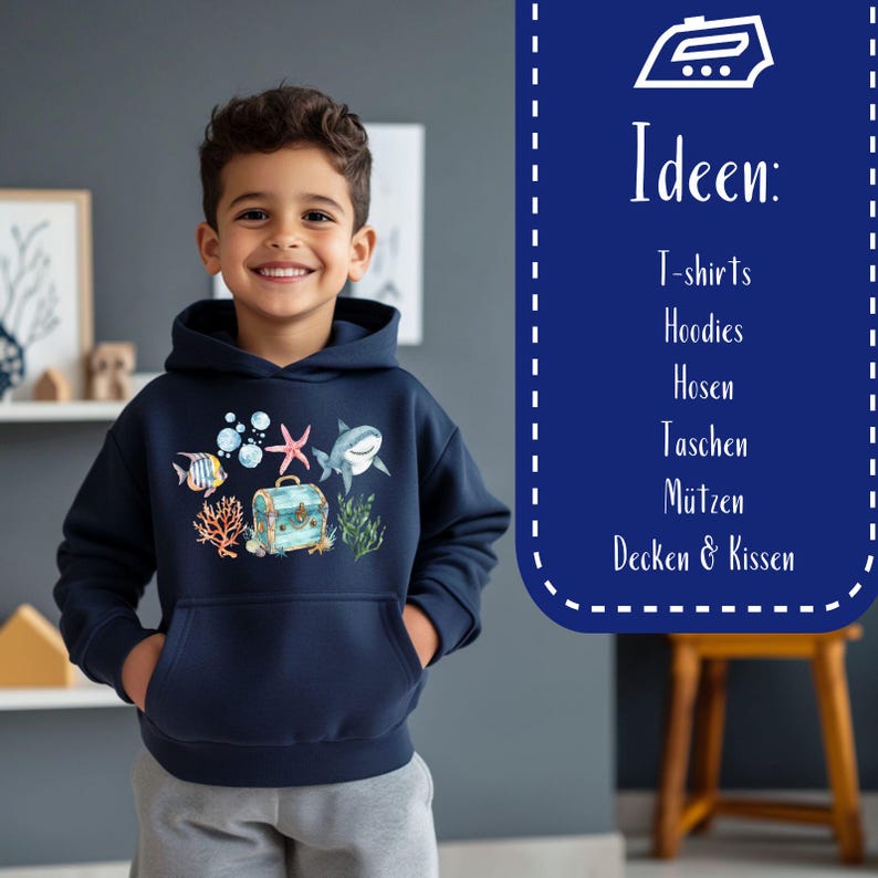 May include: A young person wearing a navy blue hoodie with a colorful underwater scene print. The print features a shark, starfish, treasure chest, coral, and fish. The text "Ideen: T-shirts, Hoodies, Hosen, Taschen, M&uuml;tzen, Decken & Kissen" is visible in the background.