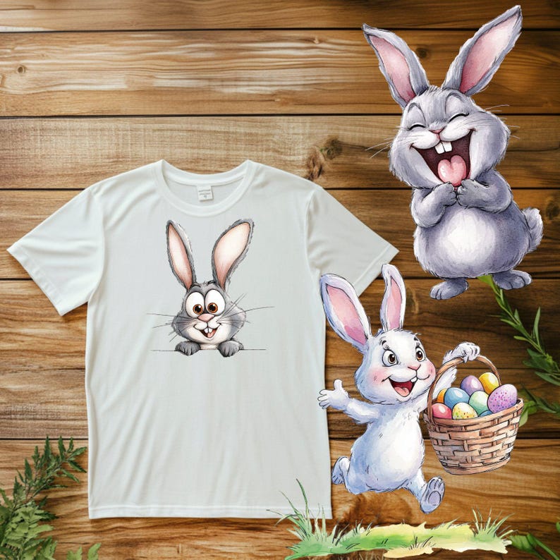 K&ouml;nnte beinhalten: Ein wei&szlig;es T-Shirt mit einem grauen Kaninchen, das hinter dem Stoff hervorlugt. Ein zweites graues Kaninchen mit einem breiten L&auml;cheln h&auml;lt einen Korb mit bunten Ostereiern.