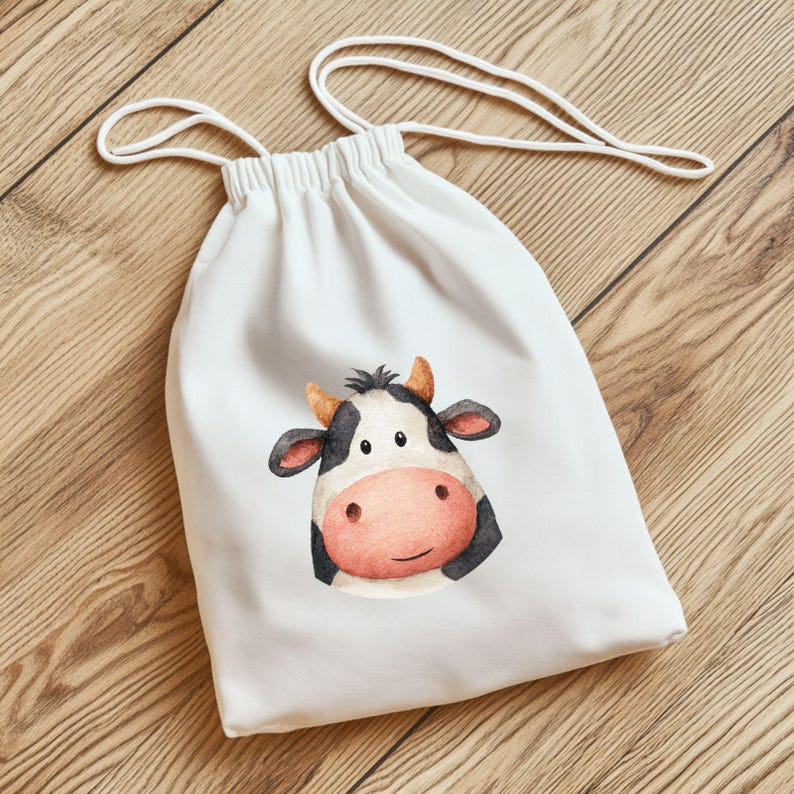 Pode incluir: Saco branco com cord&atilde;o com uma ilustra&ccedil;&atilde;o em aquarela do rosto de uma vaca. A vaca tem marcas em preto e branco, um nariz rosa e pequenos chifres marrons. O saco tem um fecho de cord&atilde;o branco.
