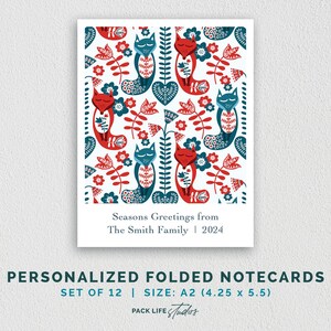 May include: Set of 12 personalized folded notecards featuring a Scandinavian-inspired design with red and blue foxes, flowers, and leaves on a white background. The notecards are A2 size (4.25 x 5.5 inches) and include the text "Seasons Greetings from The Smith Family | 2024".