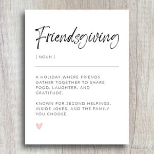 May include: A white Friendsgiving print with black script text and a definition. The definition describes Friendsgiving as a holiday where friends gather to share food, laughter, and gratitude. A small pink heart is at the bottom.