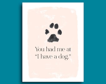 Puede incluir: Un fondo de acuarela rosa y blanco con una huella de pata negra en el centro. El texto "You had me at "I have a dog."" está debajo de la huella de pata.