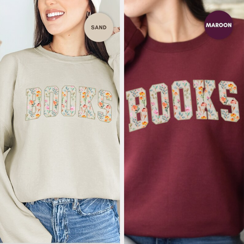Pu&ograve; includere: Due felpe con la parola "BOOKS" stampata sul davanti. La parola &egrave; composta da disegni floreali in tonalit&agrave; rosa, arancio e blu. La felpa a sinistra &egrave; color sabbia e la felpa a destra &egrave; color granata.