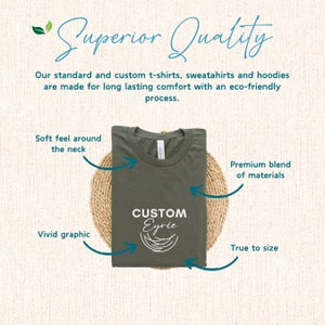 Pu&ograve; includere: Una maglietta verde piegata con una grafica bianca che dice "CUSTOM Eyrie". La maglietta &egrave; su un tappetino intrecciato e ha del testo intorno che dice "Soft feel around the neck", "Vivid graphic", "Premium blend of materials", e "True to size".