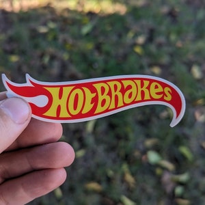 May include: A white sticker with a red and yellow flame design. The text "Hot Brakes" is written in yellow letters on the sticker.
