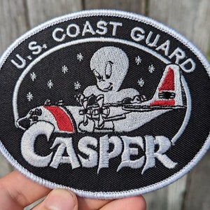 May include: A black and white embroidered patch with a white airplane, a ghost, and the text "U.S. Coast Guard Casper".