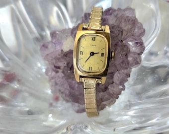 Reloj Timex vintage para mujer, de cuerda mecánica, tono dorado.