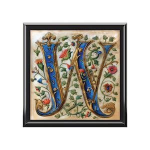 May include: A framed print of a vintage, illuminated letter W. The letter is gold with blue accents and surrounded by intricate floral designs in shades of green, red, and yellow.