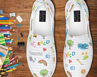 May include: White slip-on shoes with a school-themed design. The shoes feature colorful illustrations of pencils, rainbows, trees, hearts, and the letters ABCD. The word "DREAM" is also visible on one shoe.