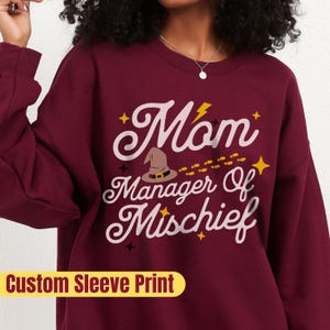 Custom Wizarding Mother&#39;s Day Gift: Fun Mom of Mischief Sweatshirt with Personalized Sleeve Featuring Her Kids&#39; Names and Wizard Houses