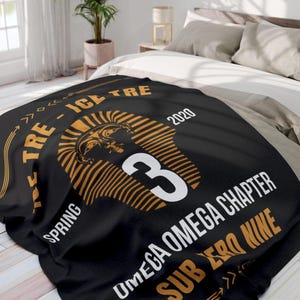 May include: Black blanket with gold and white text and graphics. The design includes a stylized pharaoh's head, the number 3, and the words "TRE - ICE TRE", "SPRING", "OMEGA OMEGA CHAPTER", and "SUB ZERO NINE". The year 2020 is also displayed.