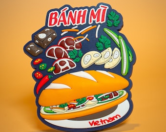 May include: A colorful magnet featuring a Banh Mi sandwich, with the word "Banh Mi" in red and white. The magnet includes illustrations of ingredients like meat, vegetables, and bread. The word "Vietnam" is also visible.