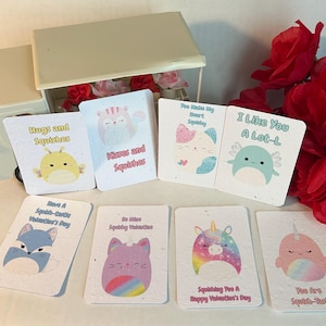 May include: Eight seed paper cards with different cute animal illustrations and Valentine's Day messages. The cards are printed on a light brown paper with a textured surface. The messages include "Hugs and Squishes", "Kisses and Squishes", "You Make My Heart Squishy", "I Like You A Lot-L", "Have A Squish-tastic Valentine's Day", "Be Mine Squishy Valentine", "Squishing You A Happy Valentine's Day", and "You Are Squish-Tastie".