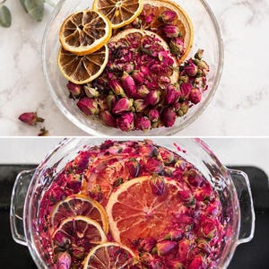 May include: A clear glass bowl containing a mixture of dried pink rosebuds and dehydrated orange slices. The top section shows the dry ingredients, while the bottom section shows the same ingredients submerged in a clear liquid, creating a vibrant infusion.