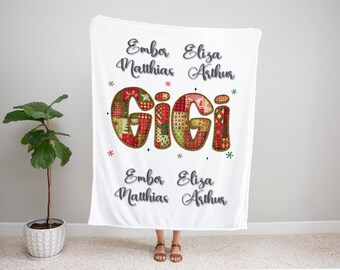 May include: White blanket with the word "GiGi" in a patchwork design. The blanket also features names and decorative stars. A festive, personalized gift.