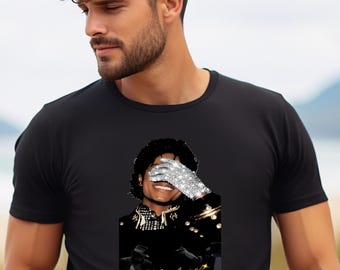 May include: A black short-sleeved t-shirt featuring a graphic print of a person with dark curly hair wearing a sparkling silver glove over their eyes. The design includes a black jacket with gold accents and the name Michael in gold script.