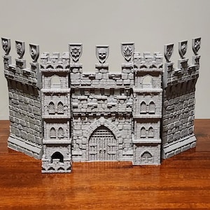 May include: A gray 3D printed castle gate with a stone wall and a gate with a skull design on the top.