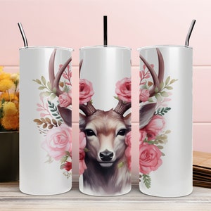Puede incluir: Un vaso de acero inoxidable blanco con un diseño floral que presenta una cabeza de ciervo con cuernos y rosas rosadas.