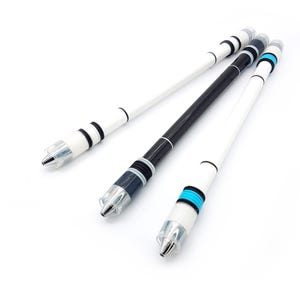May include: Three pen spinning pens are shown against a white backdrop. One pen is black, and the other two are white. Each pen has a clear tip and a design with black and blue accents.